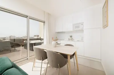 a kitchen and dining room with a table and chairs at Top-Floor 2BR, Sea and city Views & Jacuzzi in Faro