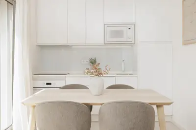 a white kitchen with a table and chairs at Top-Floor 2BR, Sea and city Views & Jacuzzi in Faro