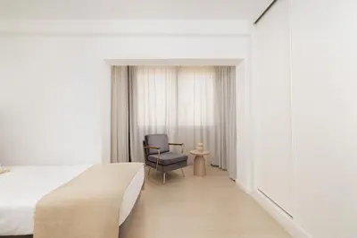 a hotel room with a bed and a chair at Top-Floor 2BR, Sea and city Views & Jacuzzi in Faro