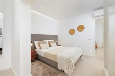 a white bedroom with a bed with white sheets and pillows at Top-Floor 2BR, Sea and city Views & Jacuzzi in Faro