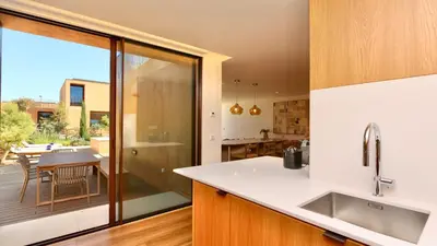 a kitchen with a view of a patio with a table at Villa Harmony - Natura Village by Cleverdetails in Quarteira