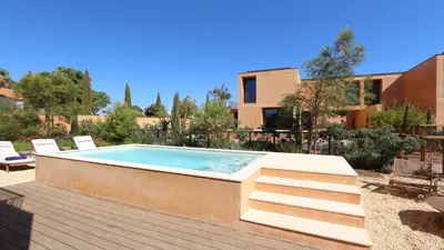 a swimming pool in a yard with chairs and a house at Villa Harmony - Natura Village by Cleverdetails in Quarteira
