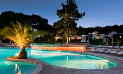 a swimming pool with people sitting on chairs and umbrellas at Bonita V3 431, Health club, tenis, golf, no Balaia Golf Village in Olhos de Água