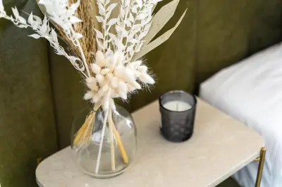 a vase of flowers on a table with a candle at Downtown, 1br with a first row view over the sea in Faro