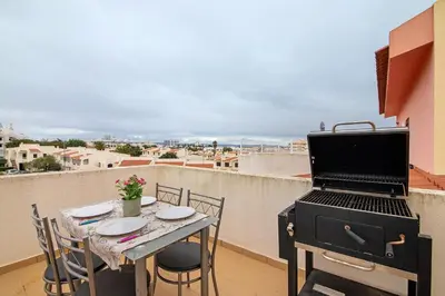 a balcony with a table and chairs on a building at Maison Jack in Albufeira
