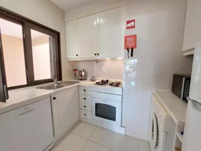 a kitchen with white cabinets and a sink and a refrigerator at Cimo do Monte Natur by SAPvillas in Vilamoura