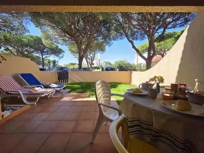 a patio with a table and chairs and trees at Cimo do Monte Natur by SAPvillas in Vilamoura