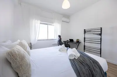 a bedroom with a white bed with towels on it at Nordic Breeze in Quarteira