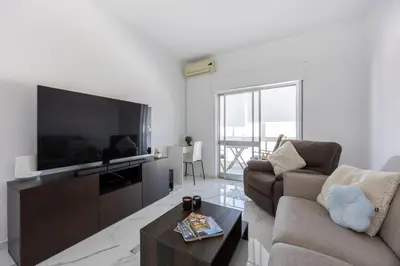 a living room with a large television and a couch at Nordic Breeze in Quarteira