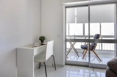 a white living room with a desk and a window at Nordic Breeze in Quarteira
