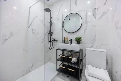 a white bathroom with a shower and a mirror at Nordic Breeze in Quarteira