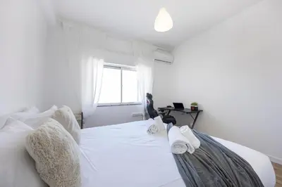 a bedroom with a white bed with towels on it at Nordic Breeze in Quarteira