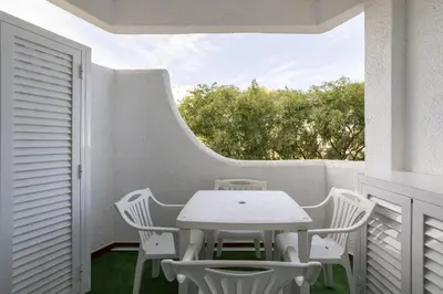 a white table and chairs on a white balcony at Sun & Sea Flat in Quarteira - Cozy Apartment Close to the Beach, by Hopstays in Quarteira