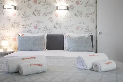 a bedroom with a white bed with towels on it at Sun & Sea Flat in Quarteira - Cozy Apartment Close to the Beach, by Hopstays in Quarteira