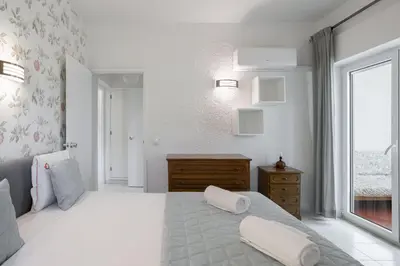 a white bedroom with a large bed and a window at Sun & Sea Flat in Quarteira - Cozy Apartment Close to the Beach, by Hopstays in Quarteira