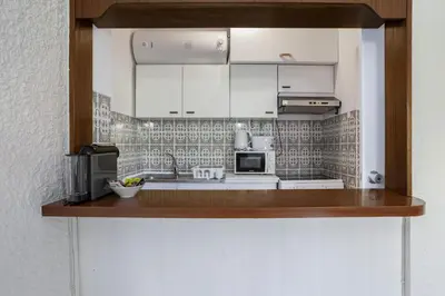 a kitchen with white cabinets and a microwave at Sun & Sea Flat in Quarteira - Cozy Apartment Close to the Beach, by Hopstays in Quarteira