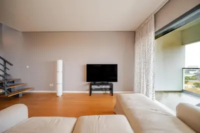 a living room with a couch and a flat screen tv at HolidaysPT - Sunset At Lux Terrace - 2 Bedroom Apt in Faro