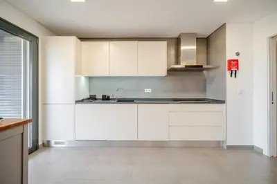 an empty kitchen with white cabinets and a sink at HolidaysPT - Sunset At Lux Terrace - 2 Bedroom Apt in Faro