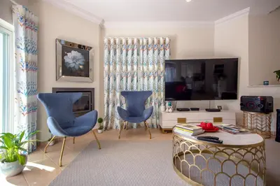 a living room with two blue chairs and a television at Amazing villa in Albufeira - Alke Vida in Albufeira