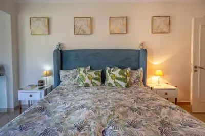 a bedroom with a large bed with a blue headboard at Amazing villa in Albufeira - Alke Vida in Albufeira
