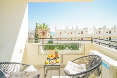 a balcony with two chairs and a table with food on it at Romantic Studio by Moje Holiday in Albufeira