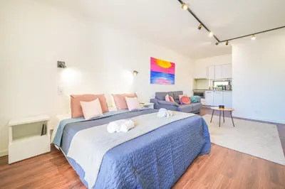 a bedroom with a large bed and a living room at Romantic Studio by Moje Holiday in Albufeira