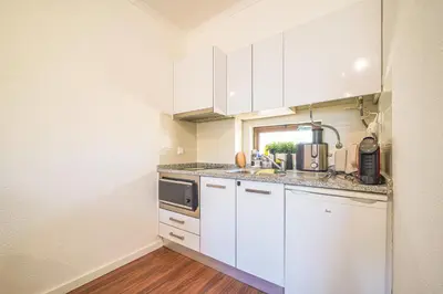 a kitchen with white cabinets and a sink at Romantic Studio by Moje Holiday in Albufeira