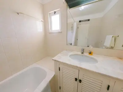 a bathroom with a sink and a tub and a mirror at Apartment with 2 bedrooms in Balaia, Olhos de Água, Albufeira in Albufeira