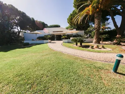 a house with a palm tree and a walkway at Apartment with 2 bedrooms in Balaia, Olhos de Água, Albufeira in Albufeira
