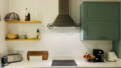 a kitchen with green cabinets and a counter top at The Lemon Tree House by IntiHolidays in Boliqueime