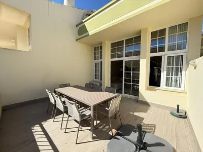 a patio with a table and chairs and a building at Villa 23 - Ponta Grande Resort in Albufeira