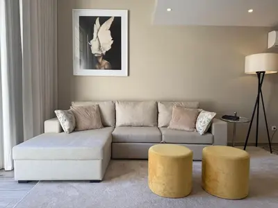 a living room with a couch and two yellow stools at Villa 23 - Ponta Grande Resort in Albufeira