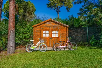 two bikes parked in front of a wooden shed at Your villa in Vilamoura in Quarteira