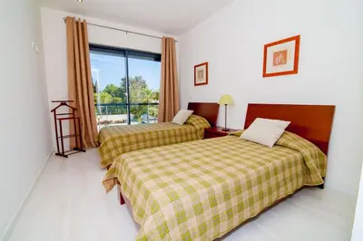 a hotel room with two beds and a window at Cavalo Preto Beach Resort Apt & Wi-Fi Nr Beach in Quarteira