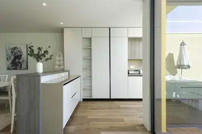 a kitchen with white cabinets and a dining room at Vilamoura Parque - Luxury Villa with pool by HD in Vilamoura