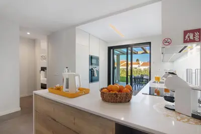 a kitchen with a counter with a bowl of oranges on it at Casa do Sol and Golf - Vilamoura in Vilamoura