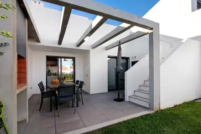 a dining room with a table and chairs on a patio at Casa do Sol and Golf - Vilamoura in Vilamoura