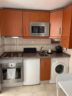 a kitchen with a stove and a microwave at Estúdio na Falésia 2 in Olhos de Água