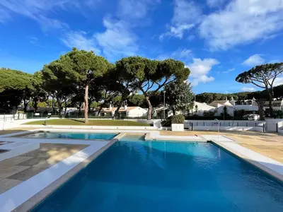 a large swimming pool with blue water at Estúdio na Falésia 2 in Olhos de Água