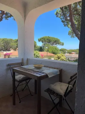 a table and two chairs on a porch with a window at Estúdio na Falésia 2 in Olhos de Água