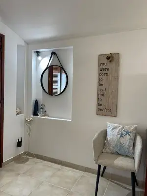 a room with a chair and a mirror on a wall at Estúdio na Falésia 2 in Olhos de Água