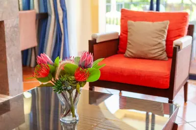 a vase of flowers on a glass table next to a chair at Vila Sol F5 Vilamoura 2BR by Enjoy your stay in Quarteira