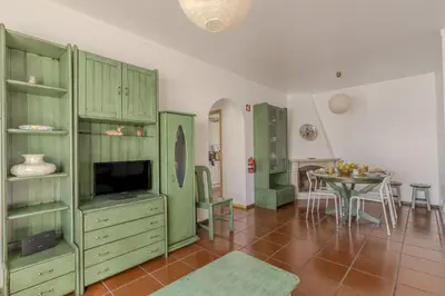 a living room with green cabinets and a table at #348 Apartment Madaleno by Home Holidays in Roja- Pé