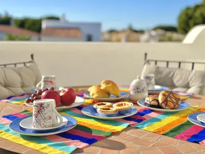 a table topped with plates of fruit and pastries at Vilamoura Brightness Apartment with Pool by Homing in Vilamoura