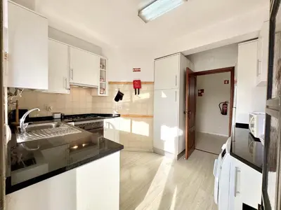 a kitchen with white cabinets and a sink at Vilamoura Brightness Apartment with Pool by Homing in Vilamoura