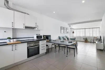a kitchen with white cabinets and a table with chairs at Casa Machadinho in Albufeira