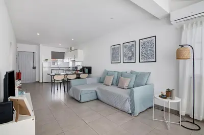 a living room with a blue couch and a kitchen at Casa Machadinho in Albufeira