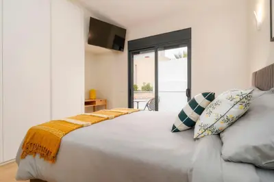 a bedroom with a bed and a bathroom with a sink at Casa De Mariposas Viola in Faro
