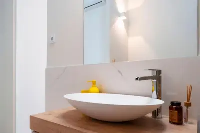 a kitchen with white cabinets and a wooden staircase at Casa De Mariposas Viola in Faro