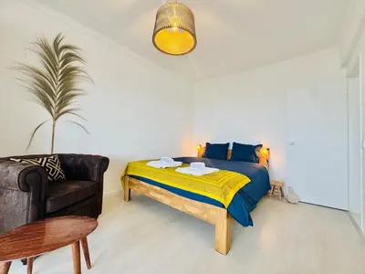 a bedroom with a bed with a yellow and blue blanket at Doble Vista Faro, Terrace with View, AC & WiFi in Faro